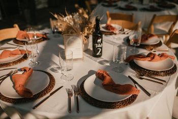Elegantly set dining table with rustic details and warm lighting.