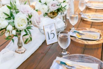 Elegant table setting with floral centerpiece and table number for a formal event.
