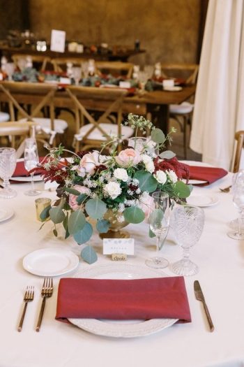 Elegantly set dining table with a floral centerpiece at a formal event.