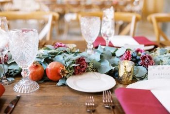 Elegant table setting with floral and fruit centerpiece at a formal event.