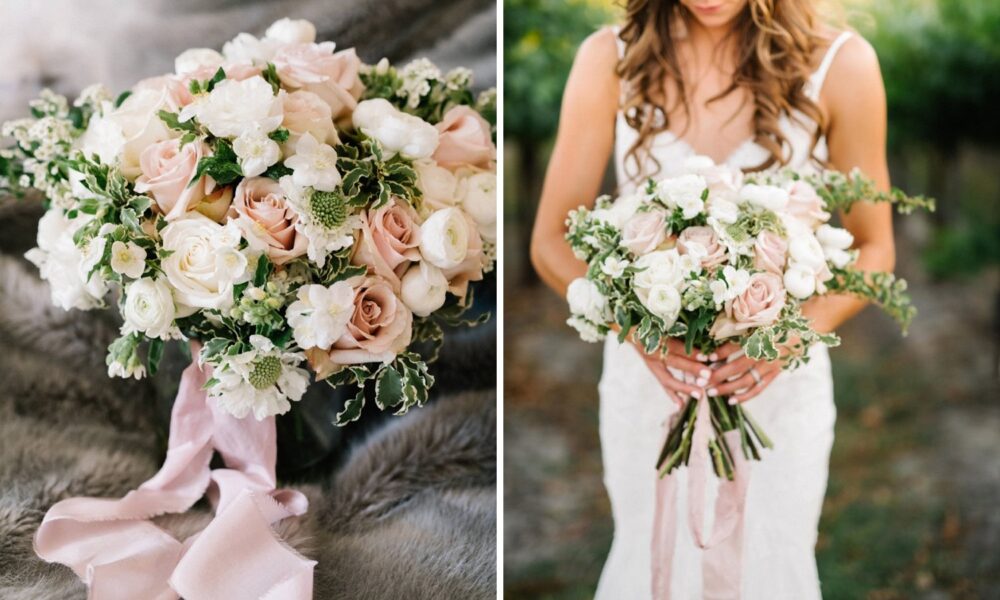 A bride holding a delicate bouquet of pale pink and white flowers with greenery and trailing ribbons.