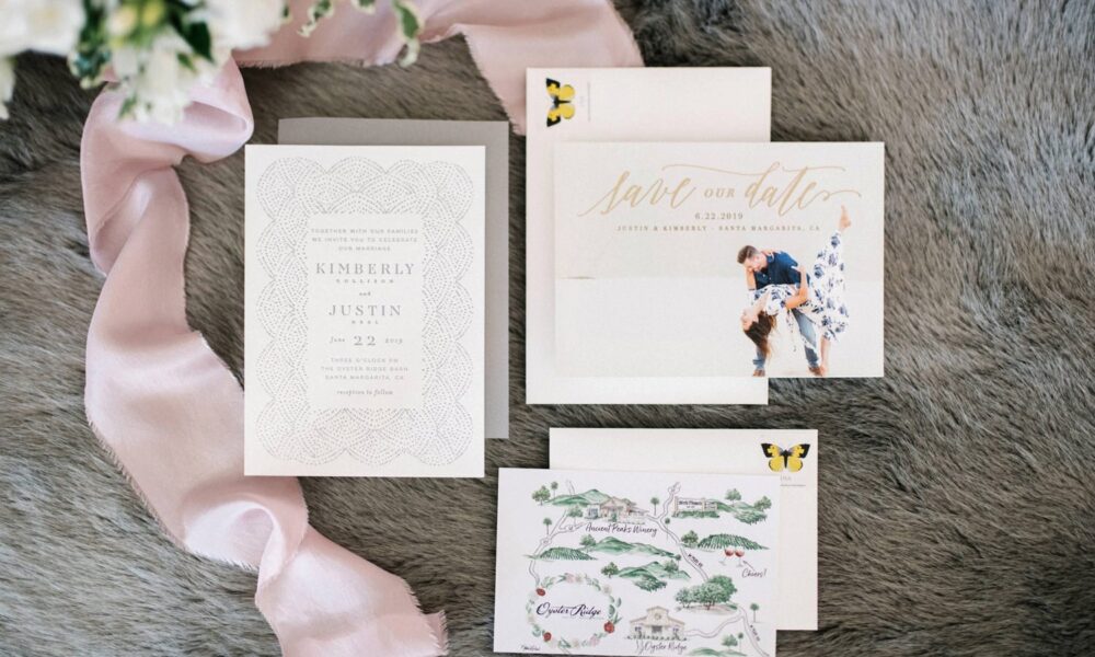 Elegant wedding stationery set including invitations and 'save the date' cards displayed with floral and ribbon accents.