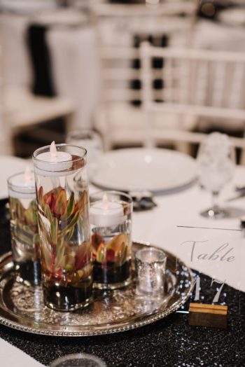 Elegant table setting with floral centerpiece and lit candles for a formal event.