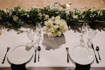 Elegant dining table setup for a formal event with floral centerpiece and fine tableware.
