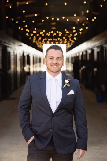 Man in a suit smiling at a wedding venue.