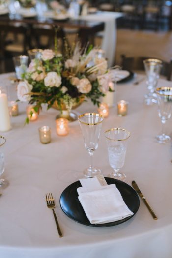 Elegant table setting for a formal event with floral centerpiece and candlelight.